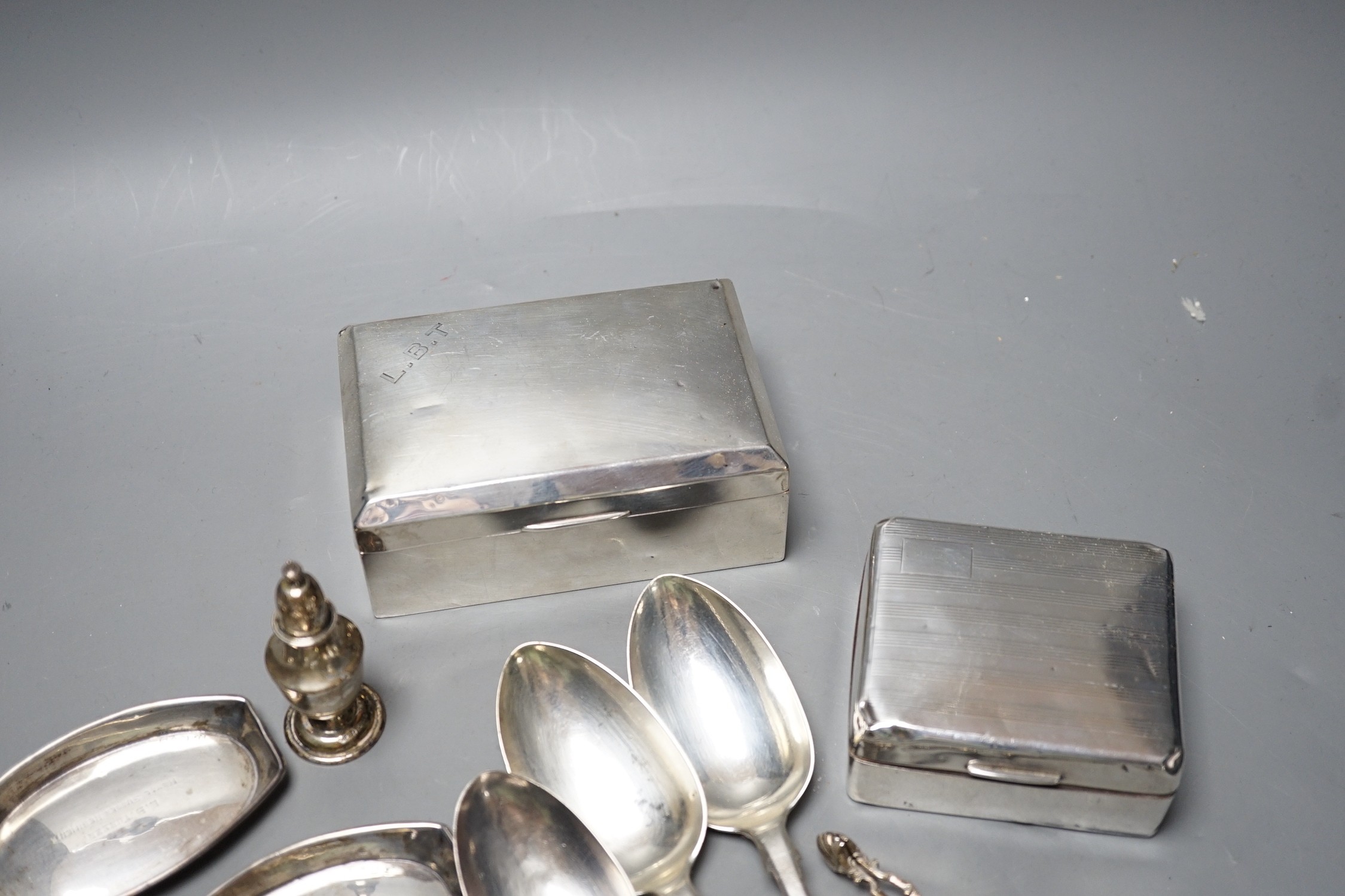 Mixed silver or white metal items including two cigarette boxes, three cigarette cases, cutlery, condiment and a napkin ring, gross